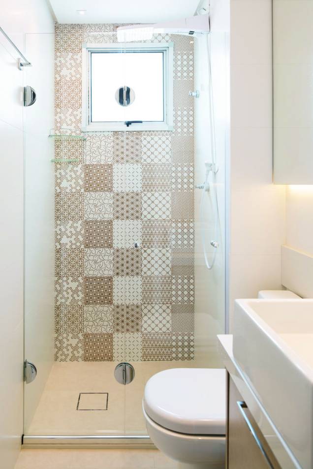 <span>Para conferir um visual sofisticado ao banheiro, a principal superfície do boxe recebeu um estiloso mosaico de azulejos com estampas de grafismos em branco e dourado (Patchwork Gold, da Decortiles. Máxxima Revestimentos). As demais paredes, por sua vez, foram cobertas com um porcelanato liso fosco (White Plain Matte, da Portinari. Máxxima Revestimentos). Projeto da arquiteta Bárbara Dundes.</span> <span>Para conferir um visual sofisticado ao banheiro, a principal superfície do boxe recebeu um estiloso mosaico de azulejos com estampas de grafismos em branco e dourado (Patchwork Gold, da Decortiles. Máxxima Revestimentos). As demais paredes, por sua vez, foram cobertas com um porcelanato liso fosco (White Plain Matte, da Portinari. Máxxima Revestimentos). Projeto da arquiteta Bárbara Dundes.</span>