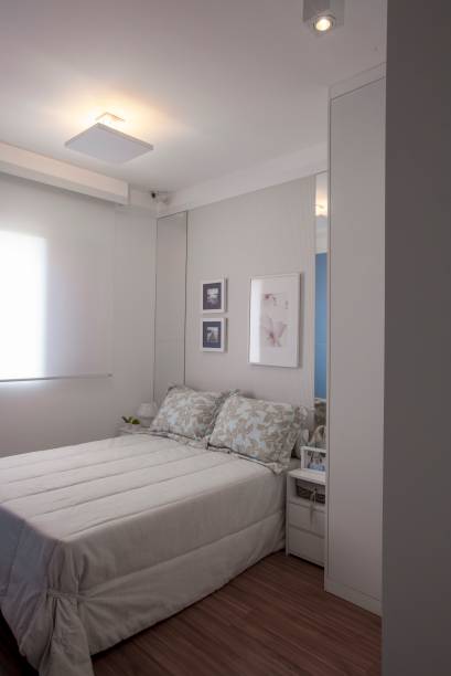 <span>No quarto do casal, os olhares se voltam para a superfície atraás da cama. Um appel com estampa discreta e clarinha foi aplicado na região central, que corresponde à largura do colchão, fazendo as vezes de cabeceira – um arranjo de quadros alegra o conjunto. As duas laterais do revestimento se completam com faixas de espleho (0,45 x 1,60 m cada), que têm a altura calculada a partir do tampo dos criados-mudos. Projeto da arquiteta Cecilia Belucci, de Campinas, SP</span>