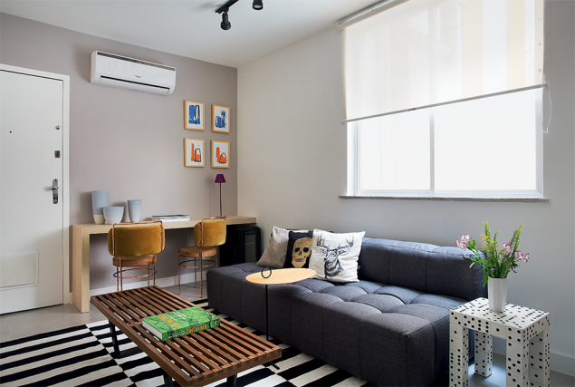 <span>Em um mesmo ambiente, de quase 13 m², sala e cozinha se distribuem de forma setorizada. No canto do estar, ao lado da entrada, a mesa acumula três funções: jantar, estudos e aparador. Amarrando a decoração, o móvel exibe os mesmos acabamentos usados na marcenaria da cozinha, que fica logo em frente. Note que o laminado (amadeirado Bilbao, da Guararapes) ainda camufla a porta que dá acesso ao dormitório. Tinta cor Nevoeiro Romano, da Coral. Projeto Tripper Arquitetura.</span> <span>Em um mesmo ambiente, de quase 13 m², sala e cozinha se distribuem de forma setorizada. No canto do estar, ao lado da entrada, a mesa acumula três funções: jantar, estudos e aparador. Amarrando a decoração, o móvel exibe os mesmos acabamentos usados na marcenaria da cozinha, que fica logo em frente. Note que o laminado (amadeirado Bilbao, da Guararapes) ainda camufla a porta que dá acesso ao dormitório. Tinta cor Nevoeiro Romano, da Coral. Projeto Tripper Arquitetura.</span>