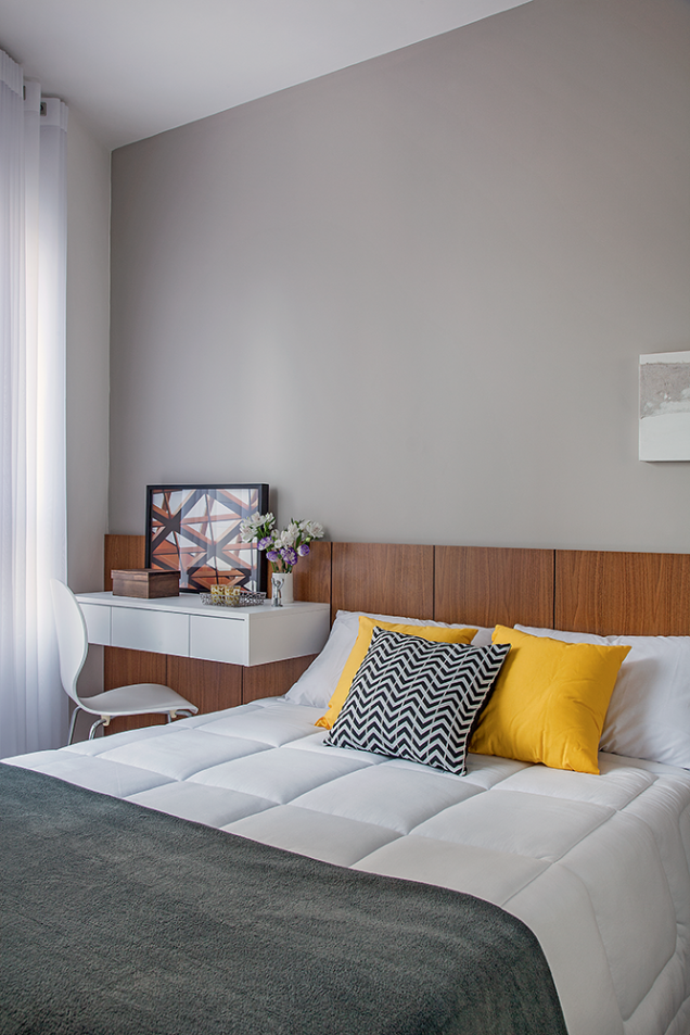 <span>O padrão amadeirado dá as caras no quarto, criando unidade visual. Ele comparece no armário – dotado de portas de correr e espelho, recursos certeiros em espaços pequenos – e no painel da cabeceira, destacada pela pintura cinza no trecho de parede logo acima. Projeto da arquiteta Luciana Tomas.</span> <span>O padrão amadeirado dá as caras no quarto, criando unidade visual. Ele comparece no armário – dotado de portas de correr e espelho, recursos certeiros em espaços pequenos – e no painel da cabeceira, destacada pela pintura cinza no trecho de parede logo acima. Projeto da arquiteta Luciana Tomas.</span>