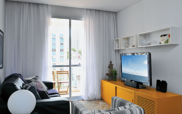 <span>Desenhado por Renata, o rack laqueado de amarelo veio na mudança. Tem portas deslizantes e um compartimento ripado para o subwoofer do home theater. </span>Projeto da <span>designer de interiores </span><span>Renata Marré.</span> <span>Desenhado por Renata, o rack laqueado de amarelo veio na mudança. Tem portas deslizantes e um compartimento ripado para o subwoofer do home theater. </span>Projeto da <span>designer de interiores </span><span>Renata Marré.</span>