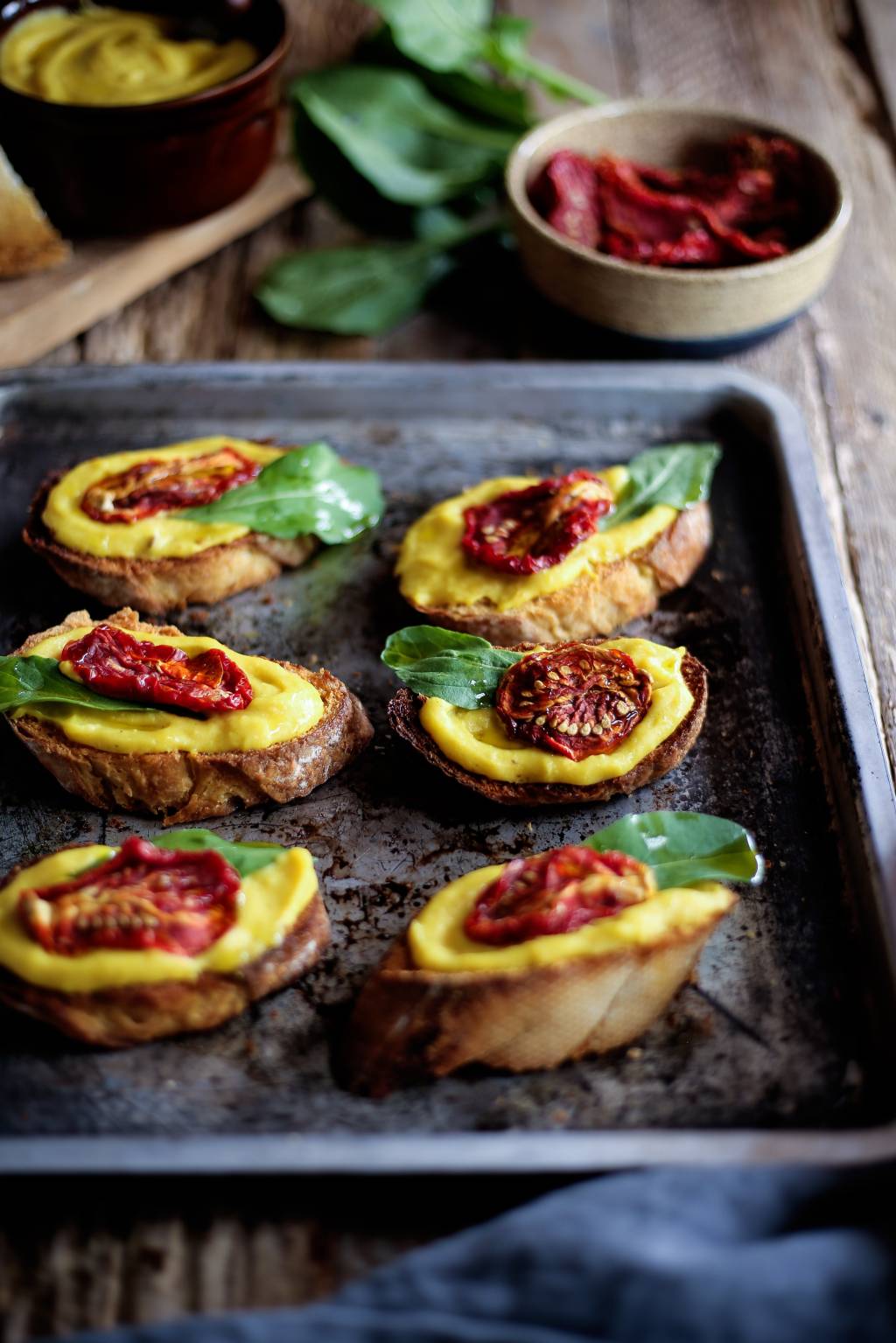 Crostini com patê de mandioquinha, tomate seco e rúcula