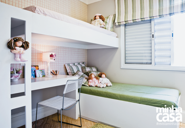 <span>Rosa e verde são os tons que enchem de graça o quarto planejado para duas meninas. Eles tingem cortina e roupa de cama e compõem um delicado xadrez no papel de parede (Kaelio). </span><span> O segredo para aproveitar o espaço de 3 x 2,40 m está na distribuição dos móveis: em vez do modelo tradicional de beliche, as camas se sobrepõem na perpendicular. Desse modo, acomodou-se uma escrivaninha sob a estrutura elevada, abrindo área para brincadeiras no centro. </span><span> “A cortina romana se limita a cobrir a janela. É mais um truque para ambientes enxutos”, fala a arquiteta Renata Cáfaro.</span> <span>Rosa e verde são os tons que enchem de graça o quarto planejado para duas meninas. Eles tingem cortina e roupa de cama e compõem um delicado xadrez no papel de parede (Kaelio). </span><span> O segredo para aproveitar o espaço de 3 x 2,40 m está na distribuição dos móveis: em vez do modelo tradicional de beliche, as camas se sobrepõem na perpendicular. Desse modo, acomodou-se uma escrivaninha sob a estrutura elevada, abrindo área para brincadeiras no centro. </span><span> “A cortina romana se limita a cobrir a janela. É mais um truque para ambientes enxutos”, fala a arquiteta Renata Cáfaro.</span>