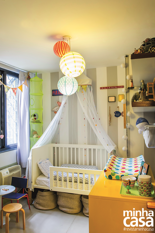 A paleta alegre e o casamento de listras, chevron e poás dão personalidade ao quarto e enriquecem a decoração. <span>A parede atrás do berço foi pintada com listras em branco e cinza, e a alvenaria vizinha recebeu um tom acinzentado mais escuro. O trocador de laca amarela e objetos de diferentes cores fazem o contraponto. “Busquei uma proposta unissex e que também não fique ultrapassada quando o pequeno crescer”, justifica a arquiteta </span><span>Alê Amado.</span>