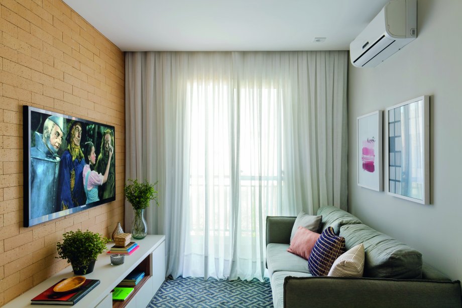 <span>Uma das estratégias das arquitetas foi investir em pontos focais, como a superfície da TV, que ganhou revestimento imitando tijolos aparentes (Anatólia Anticato Tradicional, 23 x 7 cm, da Palimanan) – além do evidente charme que agrega, ele compõe com o acabamento amadeirado de parte da marcenaria. </span><span> Esses elementos formam a base neutra, juntamente com o sofá e os demais móveis e com a pintura cinza em algumas das paredes (cor Repose Gray, ref. SW 7015, da Sherwin-Williams). A escolha de almofadas e quadros também foi pautada pela paleta suave. Projeto das</span> arquitetas Fabiana Silveira e Patrícia de Palma, do escritório SP Estudio.