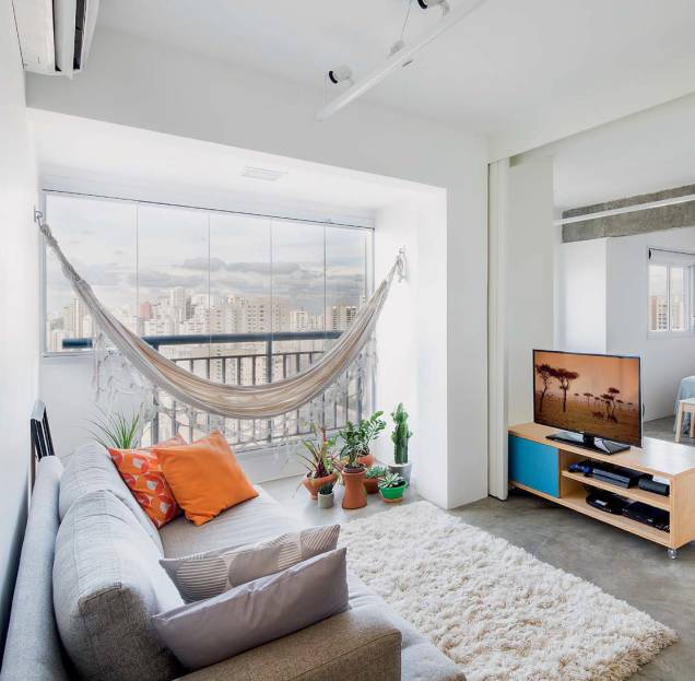 <span>A varanda já era: tem rede, mas virou parte da sala, com o mesmo piso de cimento queimado. Projeto MarcoZero Estudio.</span> <span>A varanda já era: tem rede, mas virou parte da sala, com o mesmo piso de cimento queimado. Projeto MarcoZero Estudio.</span>