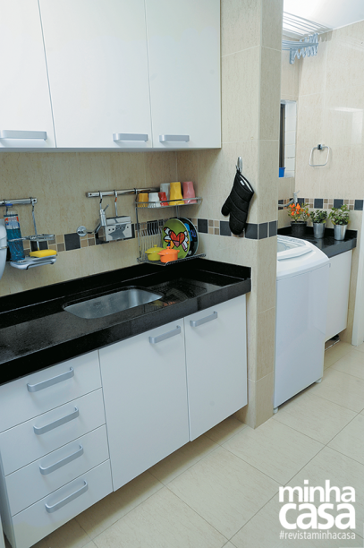 <span>Os armários preenchem as paredes laterais, aproveitando o formato alongado da cozinha. De granito preto são marcos, a bancada se repete na área de serviço. Projeto da designer de interiores Gabriela Alencar .</span>
