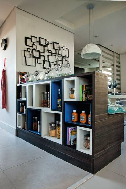 Por aqui, o destaque é o balcão multiúso desenhado por Adriana: posicionado na fronteira com a sala, de um lado, ele atua como um banco de dois lugares para a mesa de jantar e, do outro, faz as vezes de estante Por aqui, o destaque é o balcão multiúso desenhado por Adriana: posicionado na fronteira com a sala, de um lado, ele atua como um banco de dois lugares para a mesa de jantar e, do outro, faz as vezes de estante