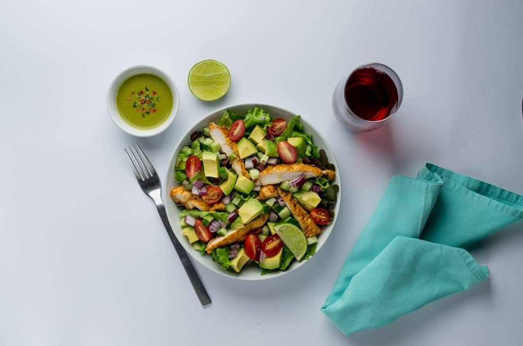 Almoço picante com salada de abacate, frango e molho jalapeño