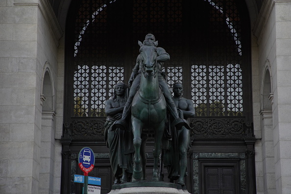 Monumento apresenta Roosevelt imponente em um cavalo, com um indígena e um escravo ao lado a pé.