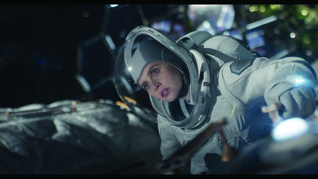 Uma astronauta está vestida com seu traje espacial e flutuando no espaço