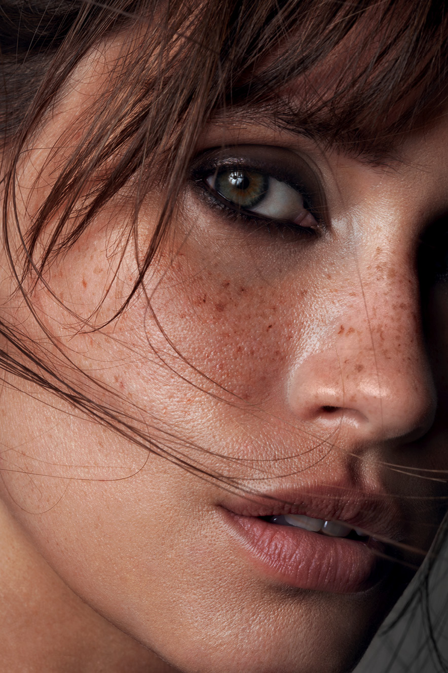 BELEZA3 (2) Em retrato, mulher maquiada com pele natural e olhos marcados por lápis preto olha para a câmera