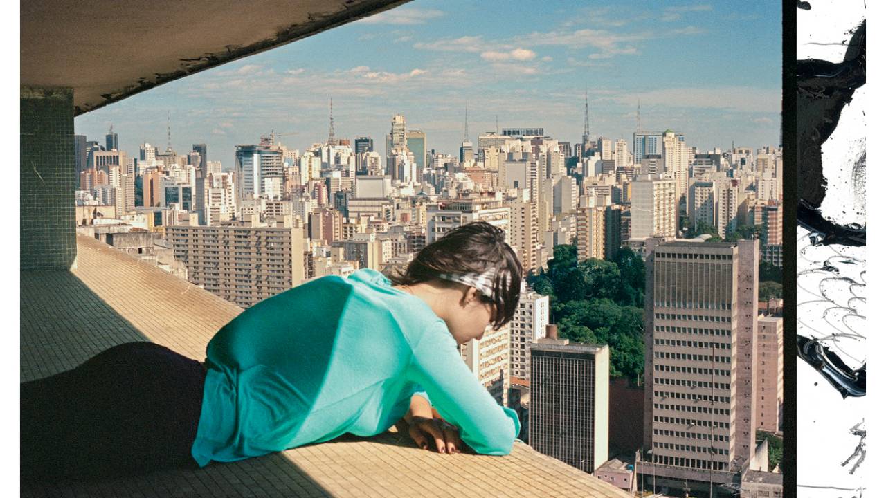 mulher olhando pela sacada de prédio