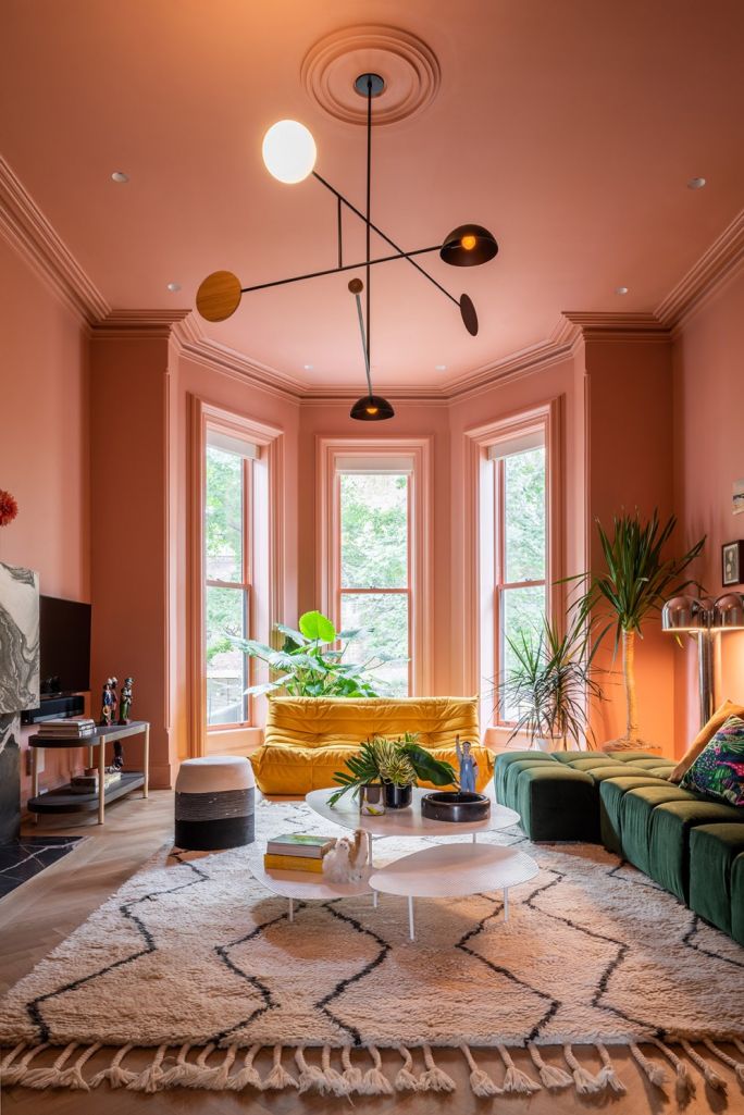 Sala com sofá amarelo e paredes pintadas com cor rosa