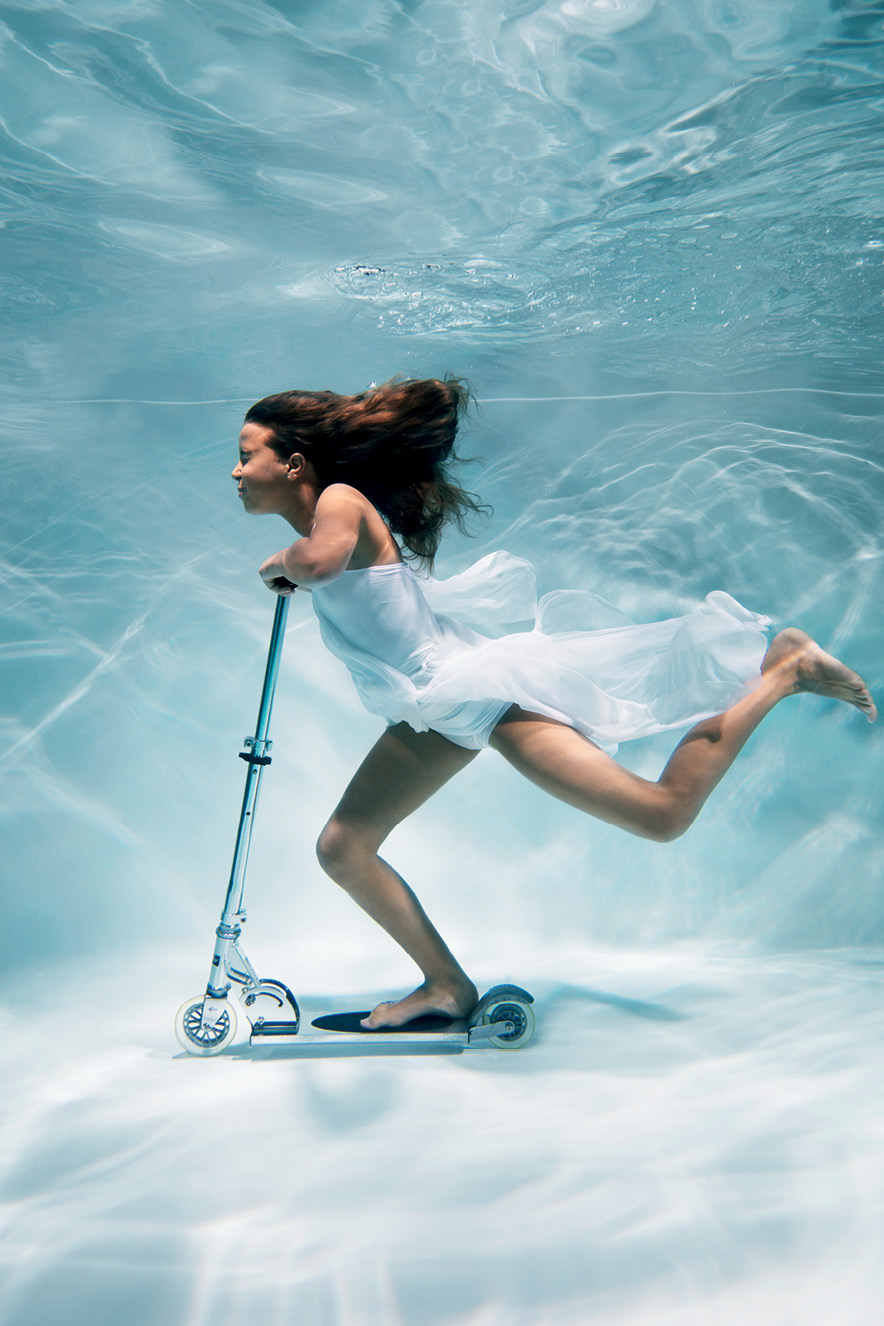 mulher andando de patinete debaixo da água