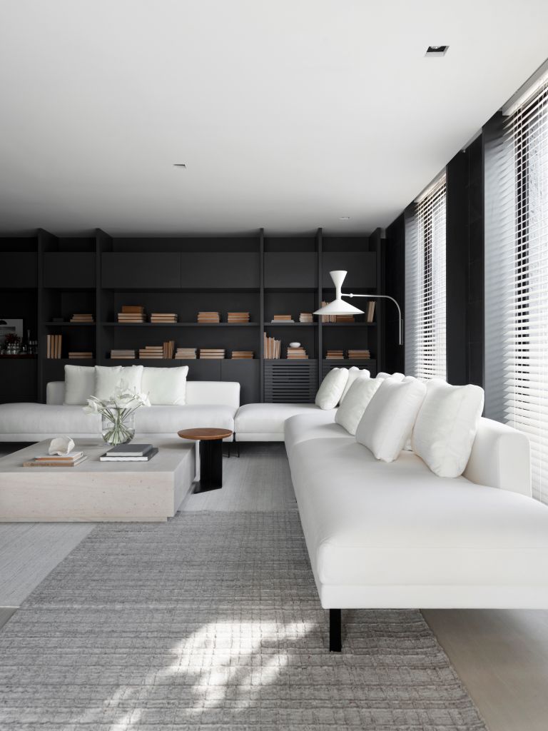 Sala de estar com sofá branco e estante preta