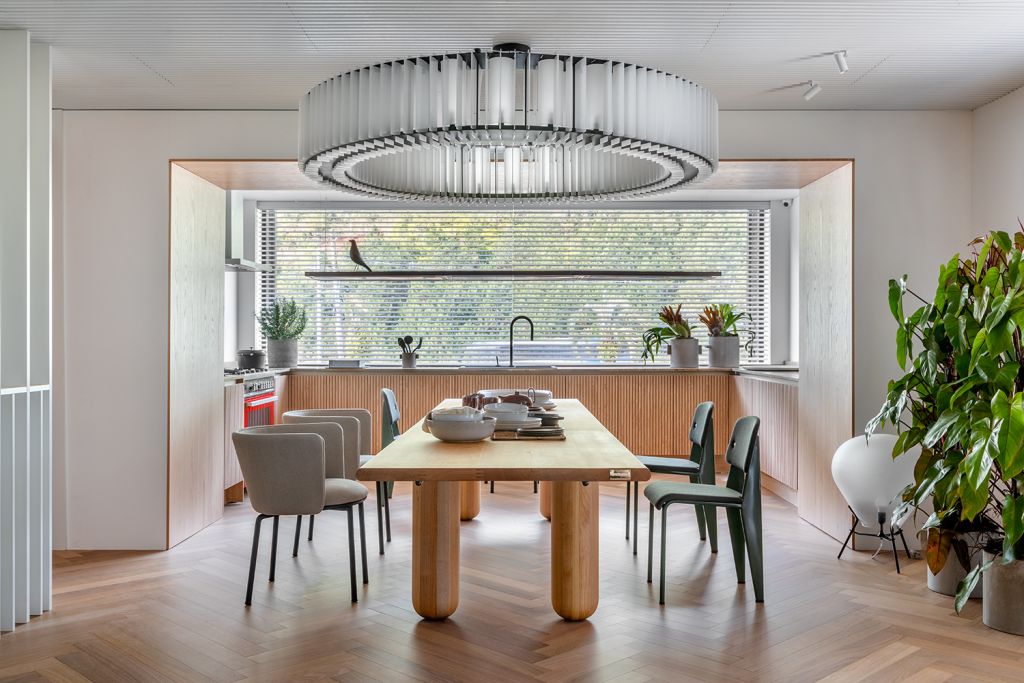 Um lounge integrado com plantas, luz natural e tons claros