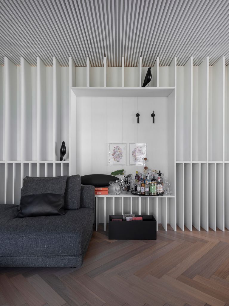 Um lounge integrado com plantas, luz natural e tons claros