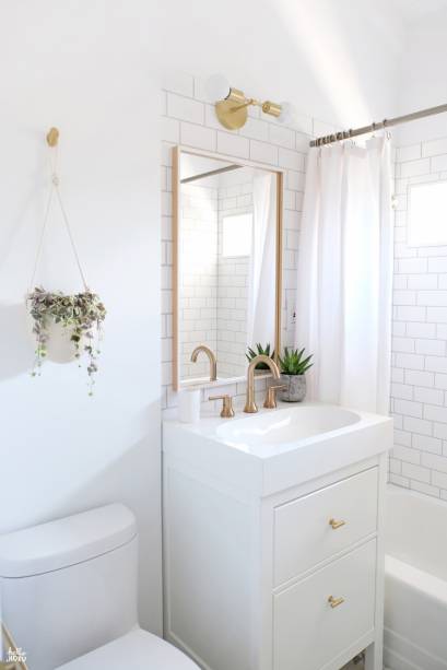 As áreas molhadas do minibanheiro, todo branco com acabamentos em dourado, foram revestidas com subway tiles. A arandela e o vaso de planta suspenso dão um toque descontraído e arrematam o décor do ambiente.