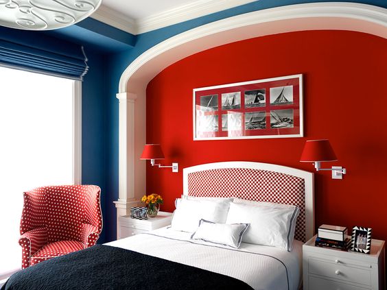 O vermelho intenso, que aparece na parede da cabeceira e nos objetos que a decoram, foi combinado com o azul jeans. Os tecidos estampados deixam a composição ainda mais ousada.