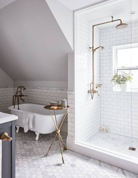 Cheio de luz natural, o banheiro da designer Allison Wilson é revestido com subway tiles. A banheira antiga, que foi restaurada, e os acabamentos em bronze dão o charme do ambiente.