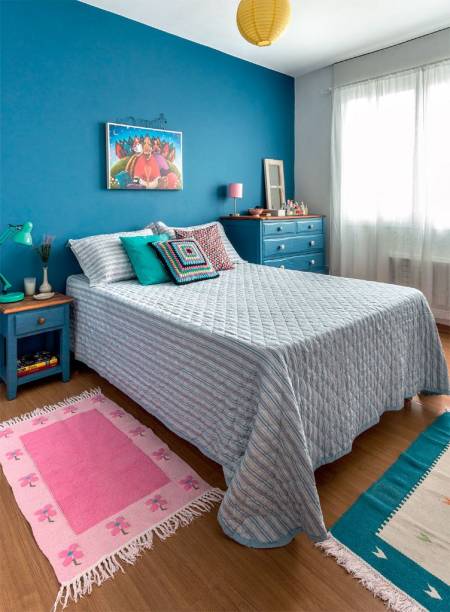 No quarto da decoradora Mara Porto, o mesmo tom de azul colore a parede da cabeceira, o criado-mudo e a cômoda. Rosa, amarelo e verde água surgem nas luminárias e almofadas.