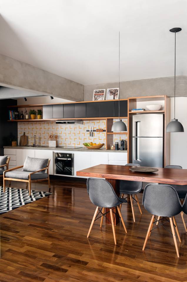 A dupla de arquitetos do escritório Casa 100, Diogo Luz e José Guilherme Carceles, escolheu cimento queimado, madeira escura e móveis em cinza para a cozinha integrada às salas de estar e jantar. A estampa amarela dos azulejos dá um toque de cor discreto. A dupla de arquitetos do escritório Casa 100, Diogo Luz e José Guilherme Carceles, escolheu cimento queimado, madeira escura e móveis em cinza para a cozinha integrada às salas de estar e jantar. A estampa amarela dos azulejos dá um toque de cor discreto.