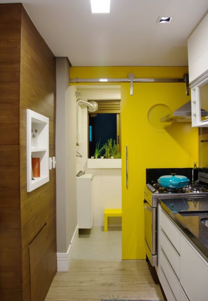 A arquiteta Amanda Schvartzman decidiu derrubar a mureta entre a cozinha e a área de serviço de seu apartamento, para que os armários ganhassem espaço. Agora é a porta de correr amarela que divide as duas áreas. A arquiteta Amanda Schvartzman decidiu derrubar a mureta entre a cozinha e a área de serviço de seu apartamento, para que os armários ganhassem espaço. Agora é a porta de correr amarela que divide as duas áreas.