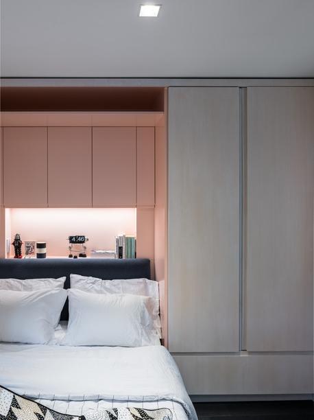 O quarto assinado pelo escritório Michael K Chen Architecture, que fica em um sótão, possui uma cama retrátil. Mas o modelo compacto do leito não atrapalhou em nada a elegância do décor: revestida em laca rosa claro, a parte interna da marcenaria revela a iluminação de LED sobre a cabeceira azul.