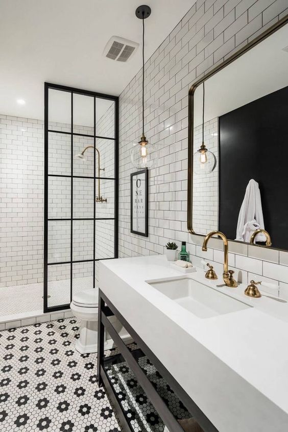 Também com subway tiles e piso hexagonal criando desenhos, este banheiro mescla elementos mais modernos ao estilo antigo, como a bancada, o pendente e as esquadrias pretas da divisória do chuveiro. Também com subway tiles e piso hexagonal criando desenhos, este banheiro mescla elementos mais modernos ao estilo antigo, como a bancada, o pendente e as esquadrias pretas da divisória do chuveiro.