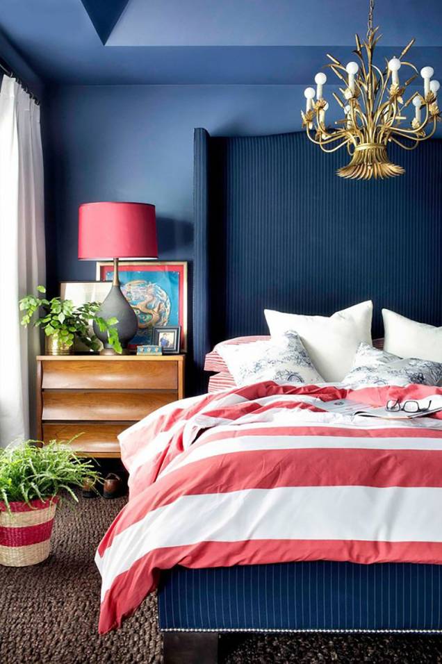 Enquanto o azul domina as paredes, o teto e a cabeceira imponente, o rosa pontua a roupa de cama, a luminária e o vaso. Enquanto o azul domina as paredes, o teto e a cabeceira imponente, o rosa pontua a roupa de cama, a luminária e o vaso.
