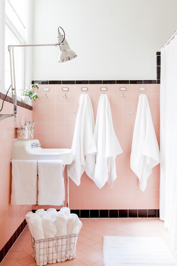 Para destacar o piso e os azulejos cor de rosa originais - com rodapé e uma borda em preto - o banheiro recebeu uma mão de tinta branca nas paredes e iluminação nova. Para destacar o piso e os azulejos cor de rosa originais - com rodapé e uma borda em preto - o banheiro recebeu uma mão de tinta branca nas paredes e iluminação nova.