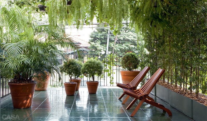 Na varanda de frente para a rua, o jardim do publicitário Zeca Ziembik foi criado para ser o espaço de breves pausas durante o dia. “Selecionei plantas que podem ser cultivadas em foreiras porque não havia ali um piso de terra”, explica. Ele optou por espécies fáceis de manter e conta com a ajuda de um jardineiro a cada dez dias, uma vez que a ideia era descomplicar a manutenção. Sustentada por um pergolado, a trepadeira tumbérgia oferece sombra às samambaias. Caixas de concreto na lateral abrigam ráfas, que resguardam o ambiente como se formassem um biombo. Buxinhos e palmeiras completam o astral do lugar. Em meio ao agito de São Paulo, um jeito de gazebo toma conta da varanda, com piso de pedra e cadeiras de imbuia tratada, compradas numa loja de móveis rústicos. “Só falta uma mesa para almoçar no verão”, planeja Zeca.