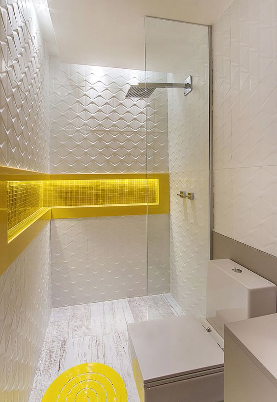 O recúo  na parede totalmente branca é bem funcional por servir como apoio para produtos e a iluminação de LED destaca o amarelo.