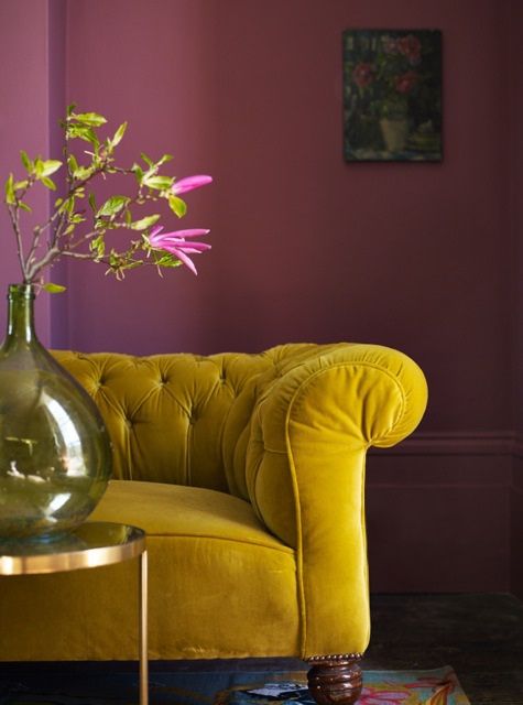 O contraste do sofá com a parede traz um estilo intenso e de personalidade.
