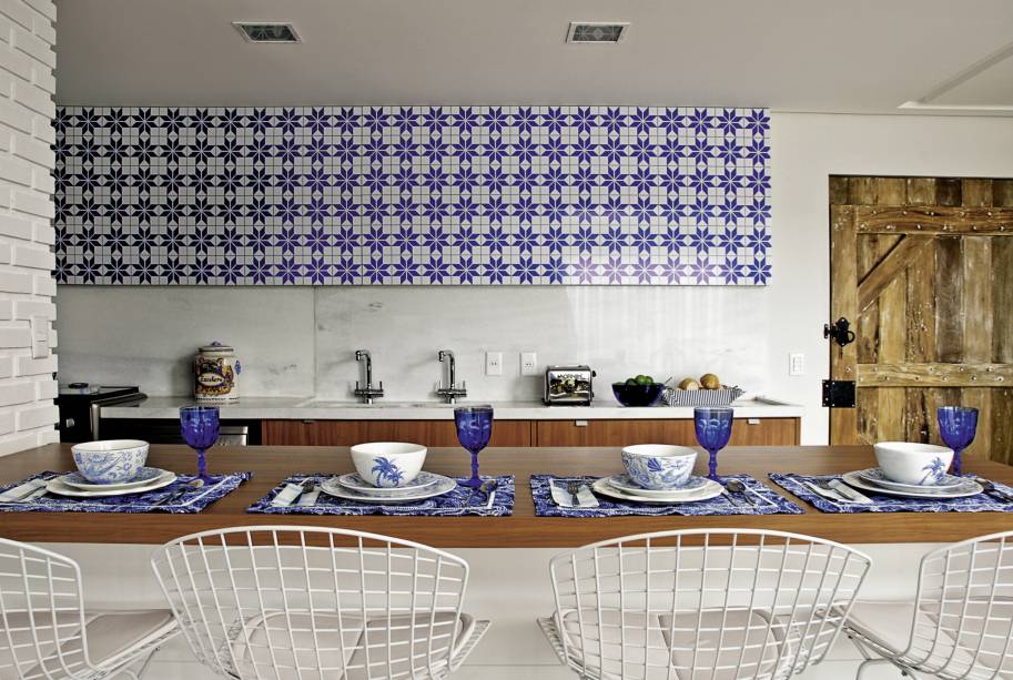 Painel que imita azulejos, armários embutidos da Dellano, banquetas altas de Harry Bertoia, da City Design, no apartamento projetado pela arquiteta <a href="https://www.andreamurao.com.br/">Andrea Murao</a>, com decoração em parceria com a arquiteta <a href="https://milenaaguiar.com.br/">Milena Aguiar</a>.