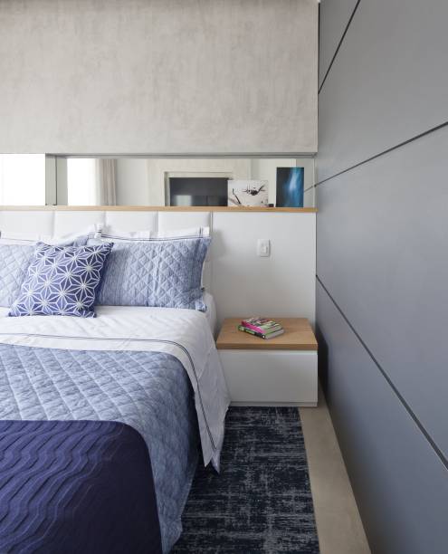 Quarto de casal com roupa de cama em tons de azul e branco. Projeto assinado pelo escritório <a href="https://www.conradoceravolo.com/">Conrado Ceravolo Arquitetos</a>.