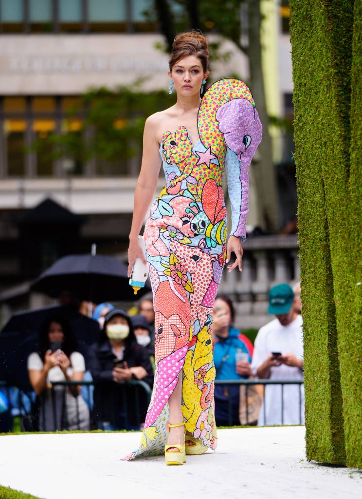 Modelo anda na passarela com um vestido colorido de um ombro só.