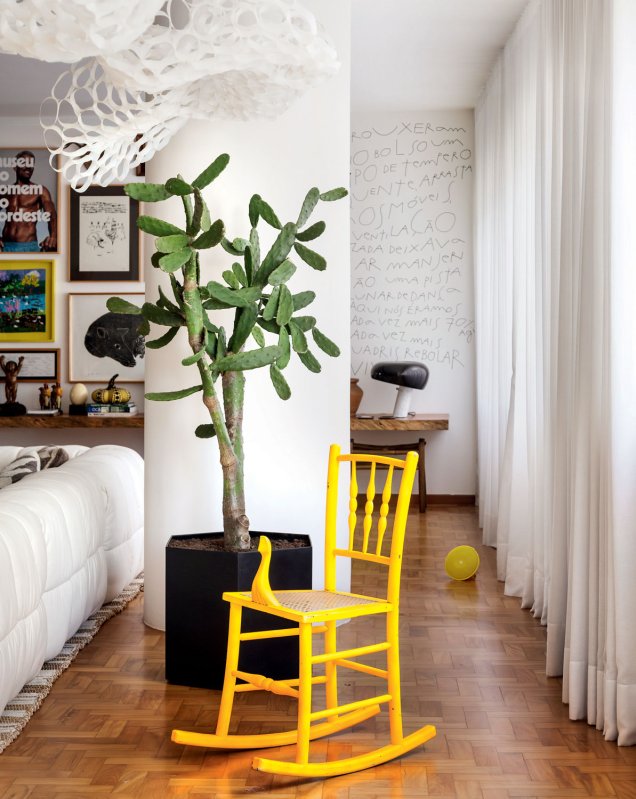 A cadeira de balanço amarela dá o tom no apartamento de Ademir Bueno e do arquiteto André Araujo.