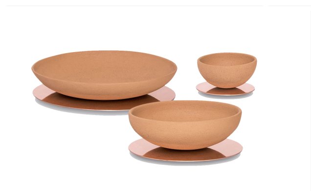 Os bowls de cerâmica Narciso (15 x 8 cm, 30 x 10 cm e 45 x 10 cm) são refetidos no apoio de cobre polido. De Guilherme Wentz, custam a partir de 1 128 reais na Decameron.