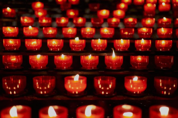 Many candles lit in dark church