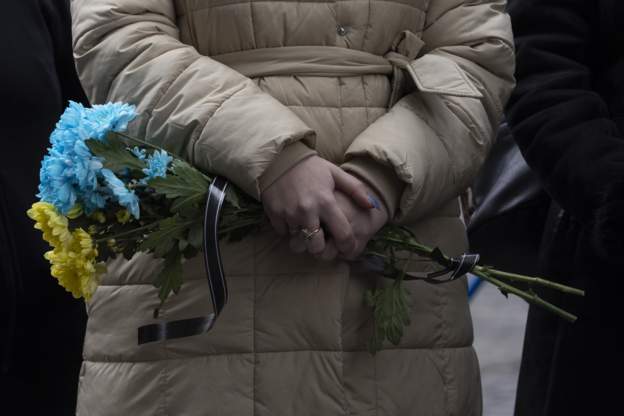 Uma mulher segura flores durante um serviço no cemitério Lychakiv durante um funeral conjunto para dois soldados que morreram no leste do país durante os recentes combates, em 08 de março de 2022 em Lviv, Ucrânia