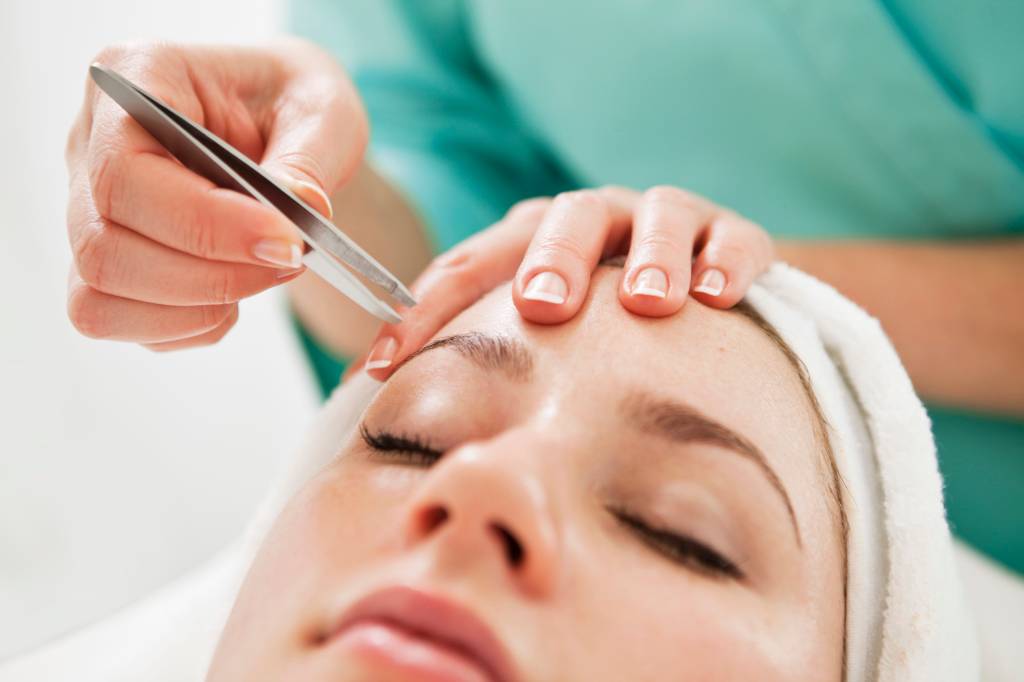 Close-up of a young woman having eye-brows plucked Foto