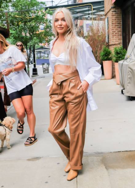 Alex Cooper apostou na combinação de camisa branca oversized com top branco e calça de couro.