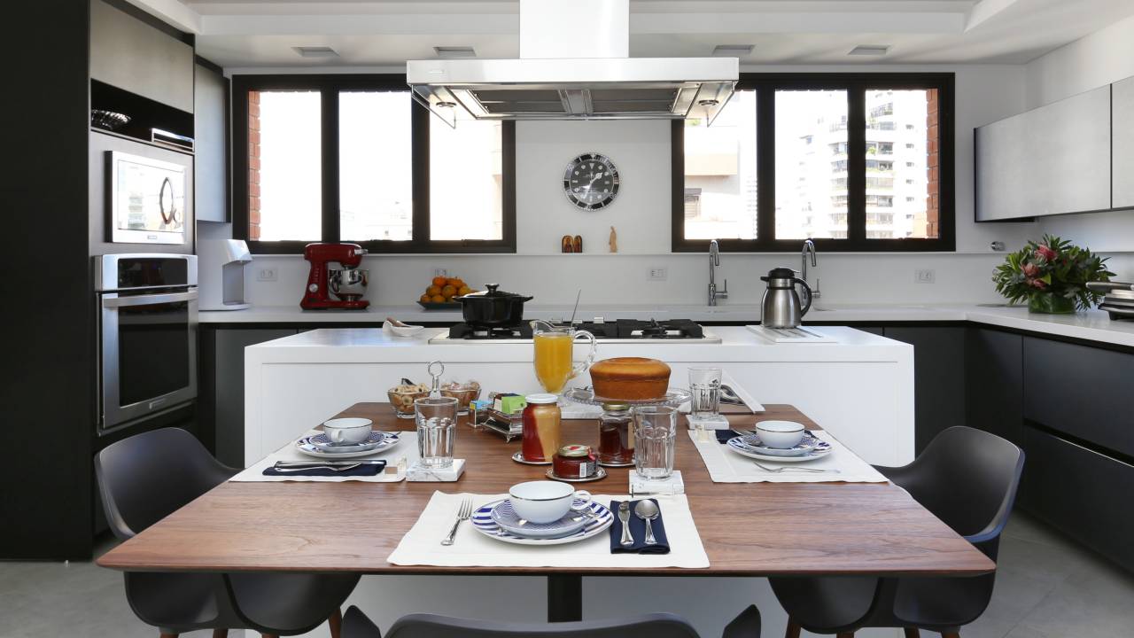 Cozinha com ilha central e mesa de jantar em área integrada