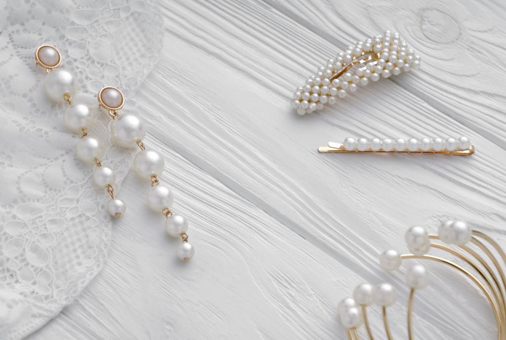 Pearl golden Earrings, hairpins and bracelet on white background Presilhas de noiva