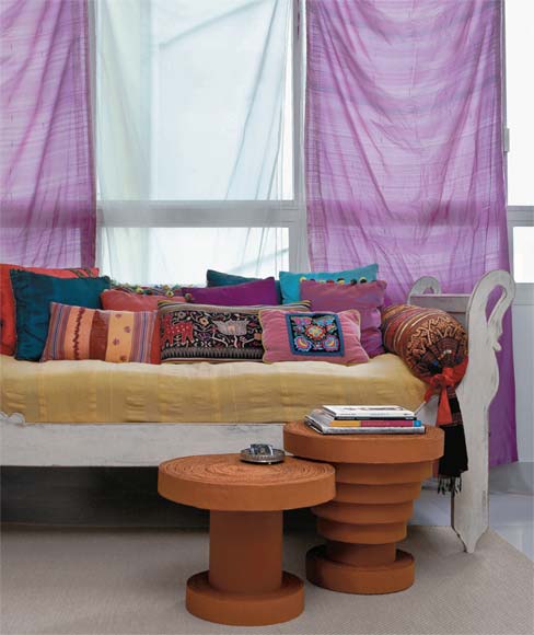 Sáris indianos fazem às vezes de cortina, e almofadas criadas com tecidos d...