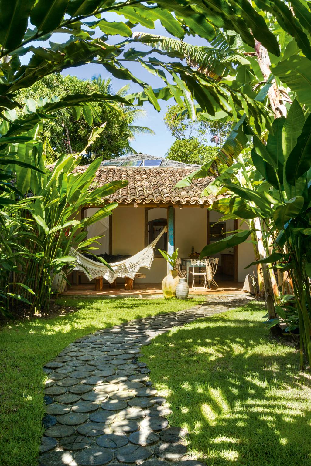 Caminho entre as árvores para chegar até a aconchegante casa