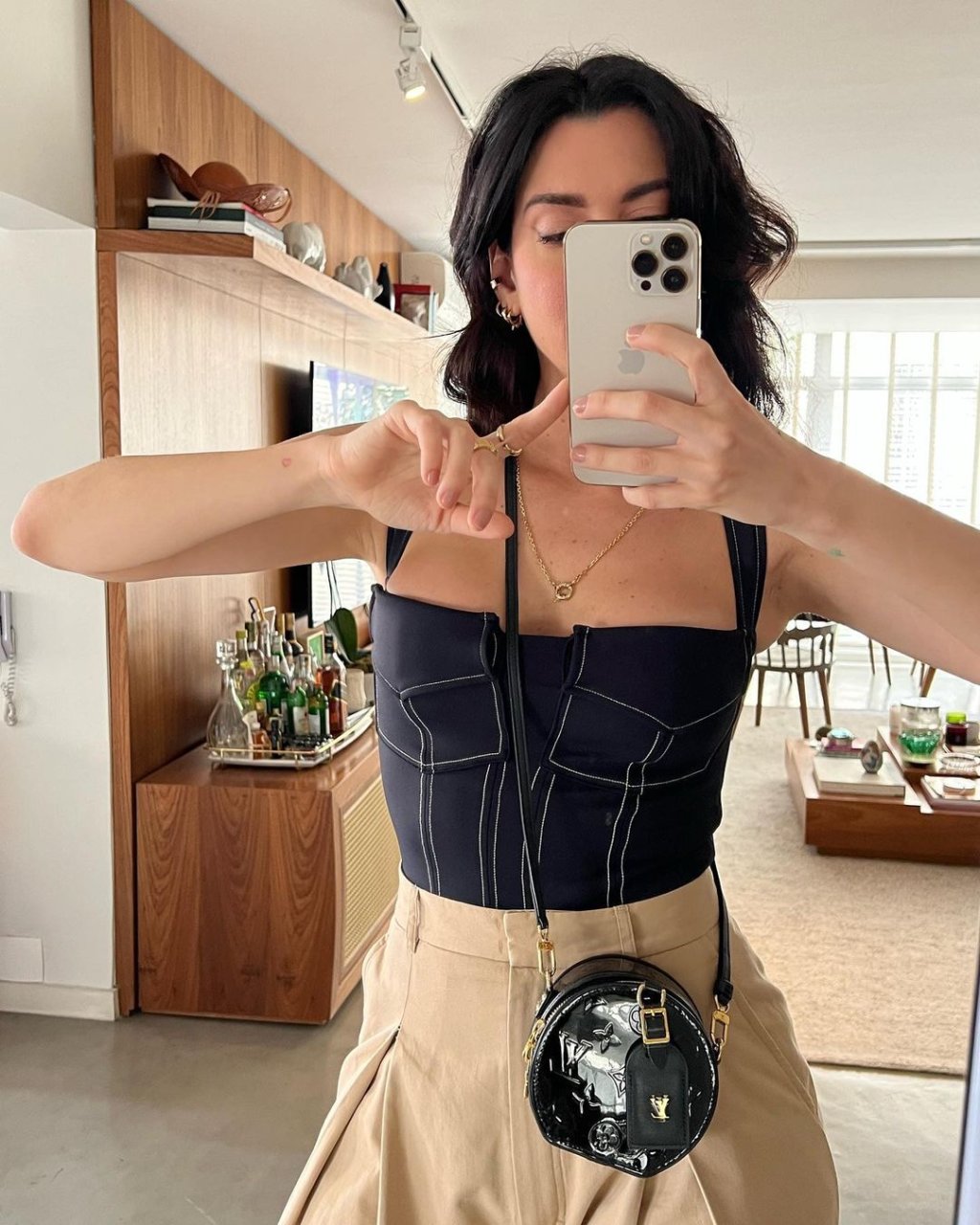 A influencer Camila Coutinho usa um maiô combinado com uma calça de alfaiataria.