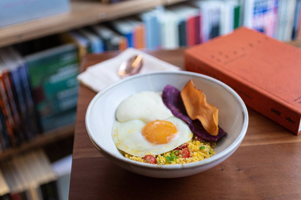 Cuscuz de milho com creme de queijo mandala, chips de batata-doce e ovo frito, uma das opções do menu do Cuia Café Cuscuz de milho com creme de queijo mandala, chips de batata-doce e ovo frito, uma das opções do menu do Cuia Café